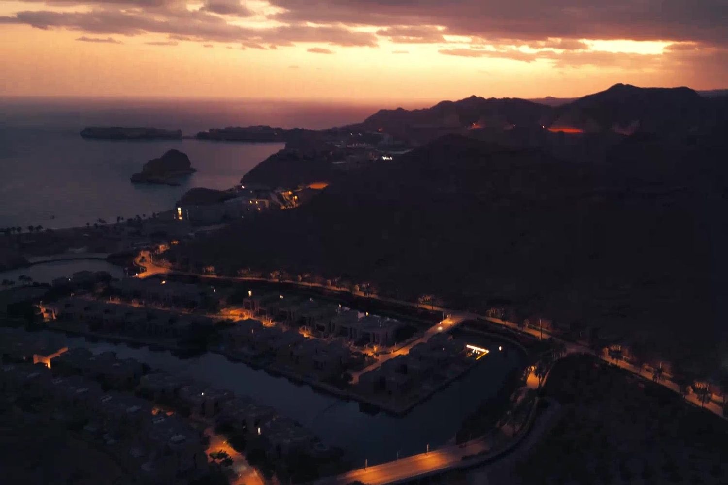 Muscat Bay at dusk — aerial view of the community and the bay