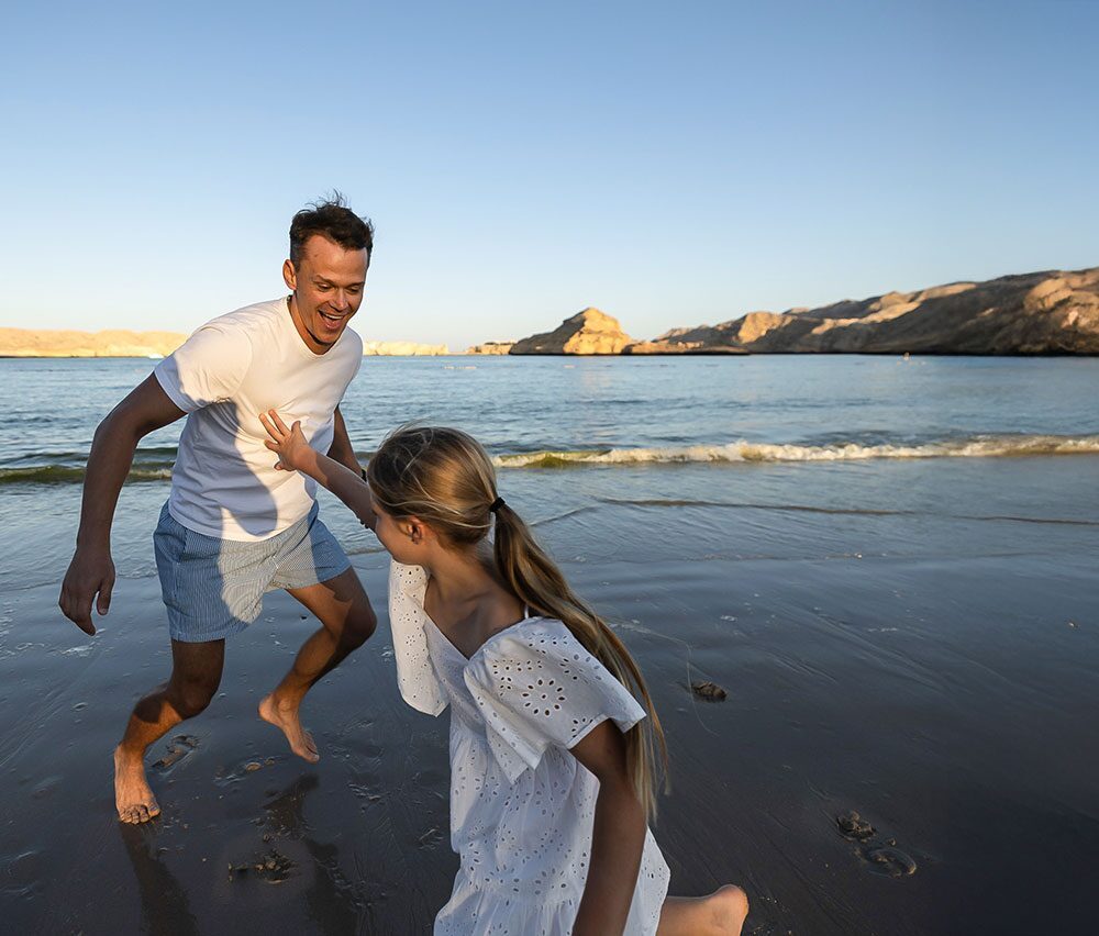 Family playing on the shore of the Gulf of Oman